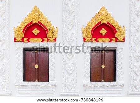 Thai art style of window in public temple with cha-da on top of window, Thailand