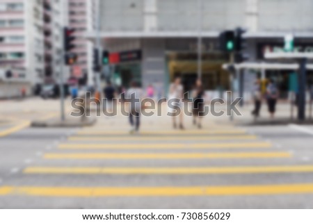Blurred image of people moving in crossway on city street in Hong Kong. 