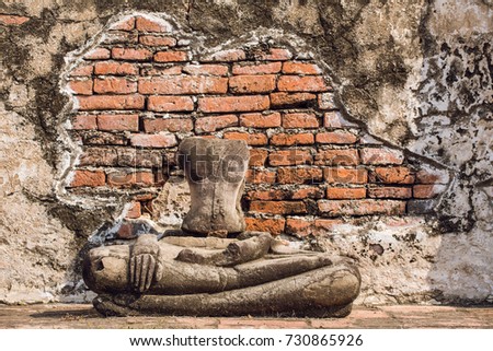 Headless Buddha statue along a temple wall at Wat Mahathat, Temple of the Great Relic, in Ayutthaya, Thailand