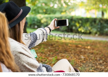 Two girlfriends taking selfie in the park