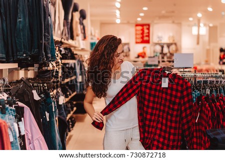 Picture showing beautiful woman shopping for clothes.