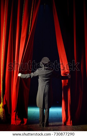 the actor opens a theater curtain Royalty-Free Stock Photo #730877290