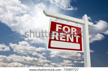 Left Facing For Rent Real Estate Sign Over Clouds and Sunny Sky with Room for Text.