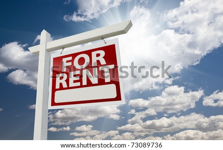 Right Facing For Rent Real Estate Sign Over Clouds and Sunny Sky with Room For Text.