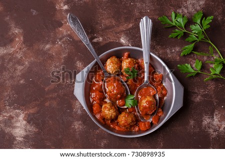 Traditional spicy meatballs in tomato sauce on concrete background. Selective focus.