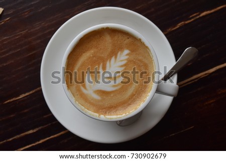 a cup of coffee with a pattern on the foam