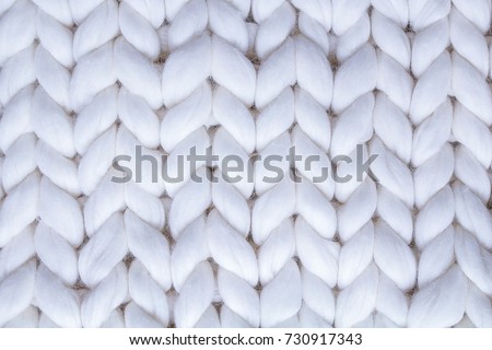 background textile white knitted plaid of thick woolen yarn / white knitted plaid Royalty-Free Stock Photo #730917343