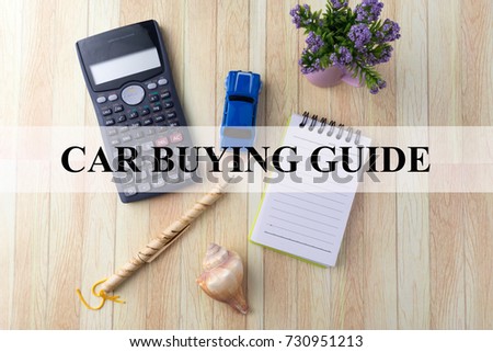 CAR BUYING GUIDE text overlay on background with calculator, toy car, flower decoration, notepad, seashell and pen