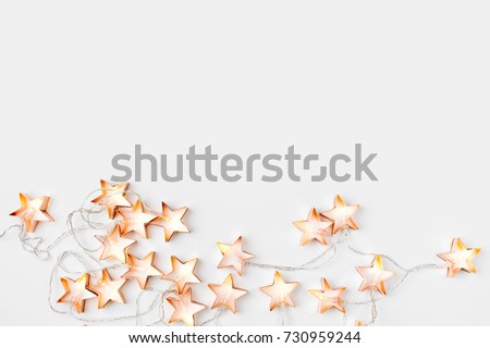 Warm star-shaped light garlands, festive decorations with copy space.  Christmas concept. Flat lay, top view Royalty-Free Stock Photo #730959244
