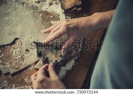 Woman making Christmas gingerbread cookies in kitchen 