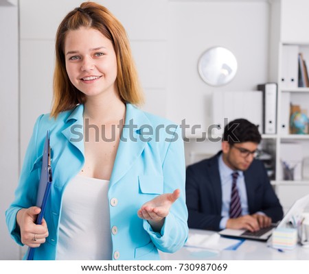 Smiling young businesswoman politely welcoming to company office