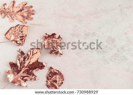 Autumn rose gold colored leaves, creative flatlay on white marble background. Copy space for text