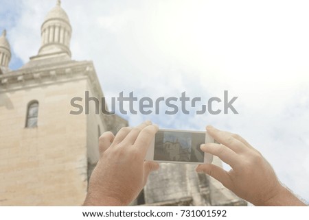 Tourist hands holding smart phone taking photo of Perigueux, France