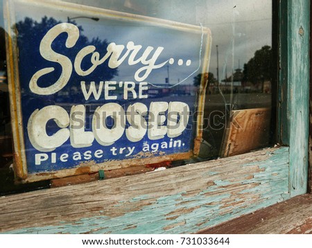 Sorry... WE'RE CLOSED sign in old window with peeling paint