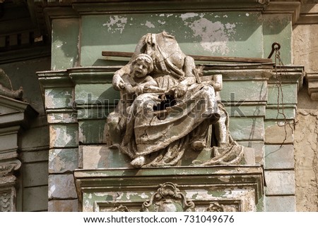 Detail of sculptural design of old Baroque building of  18th century. Carved decorations, bas-relief, coat of arms and heraldry, ornament on facade of building. Sculpture on facade