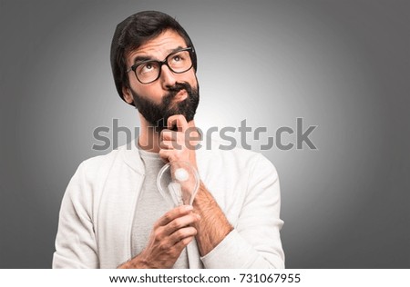 Hipster man holding a bulb on grey background