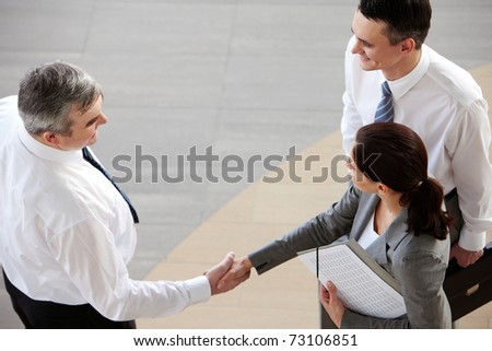 Image of business partners handshaking after signing contract