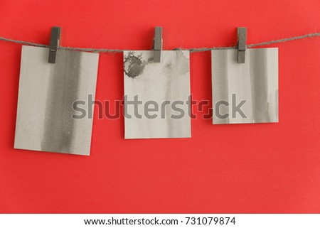Clothespin with colorful frame card hanging on rope on red background