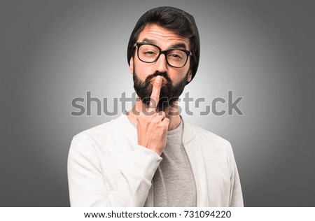 Hipster man making horn gesture on grey background