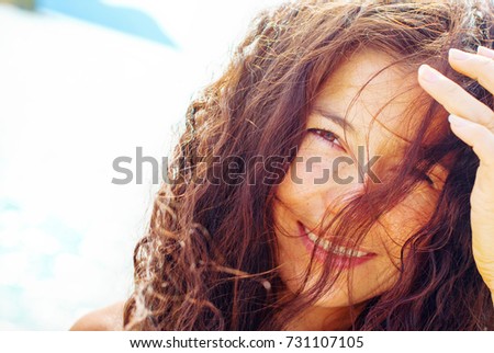 Young Beautiful Woman Looks at Camera. In Sunshine on the background of sea