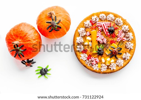 Pie for halloween with gummy spiders on white background top view.