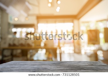 Selected focus empty brown wooden table in Cafe of abstract blurred background of light bokeh.