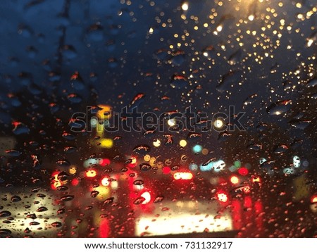 Blurry background, Raindrops on the windshield, street lights at night in rainy day, abstract of colorful bokeh.
