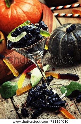 Halloween black candy and pumpkin guards ol old wooden background,  selective focus