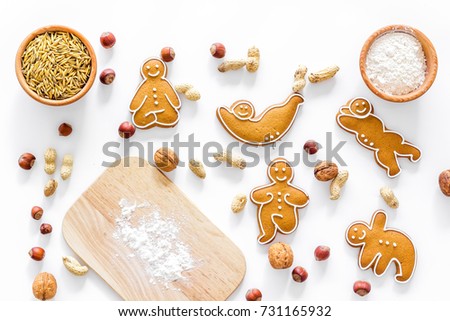 Healthy food for sportsman. Cookies in shape of yoga asanas near nuts on white background top view