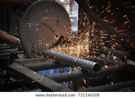 Grout Tube being cut into shape and measurement at a Pre Cast Concrete yard for structural building panels by a mitre saw with sparks flying