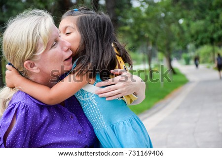 Grandmother and granddaughter hugging and kissing