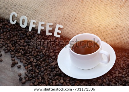 Cup of hot Americano and Roasted coffee beans, can be used as a background with text of wood, Coffee reduces the risk of heart disease and diabetes.