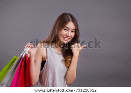 woman shopper with shopping bag pointing up sideway