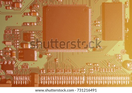 A toned macro image of a computer board with many small technological elements. Extremely shallow depth of field. Abstract technological background