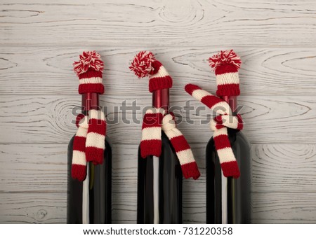 Merry Christmas and a Happy New Year! Bottles of wine in a knitted cap of Santa Claus. Selective focus