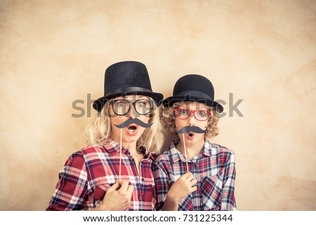 Funny woman and kid with fake mustache. Happy family playing in home. Movember concpet Royalty-Free Stock Photo #731225344