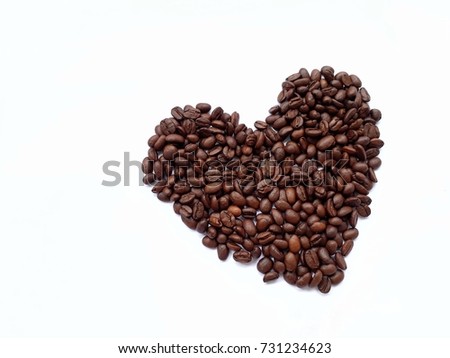 Closeup top view of heart shape coffee beans on white background (Selective focus).