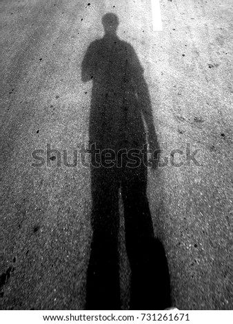 The shadow of an asian young men walking on the street.
