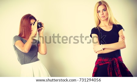 Photographer and model. woman shooting images, taking photos with camera, photographing blonde woman