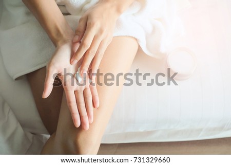 Asia woman sitting on bed and applying cream on Hand. Royalty-Free Stock Photo #731329660