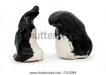 A pair of black and white penguins made in a children's art class on a white background