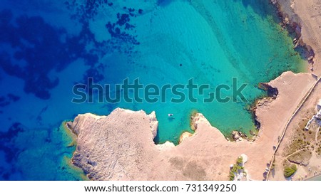 Aerial drone top view photo of beautiful volcanic caves of Xylobatis or Ksylobatis with deep blue waters, Koufonissi island, Cyclades, Greece