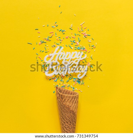 an ice cream cone and confetti for happy birthday party. minimal flat lay