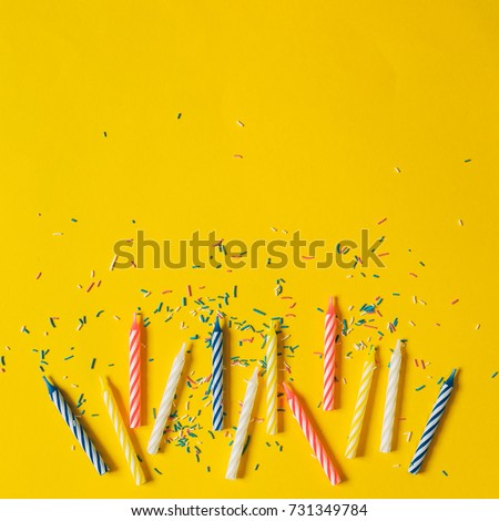 colorful candle for birthday party on a yellow background, flat lay, top view