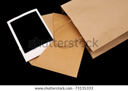 A vintage envelope in a paper bag with instant photo inside