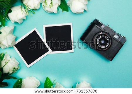 vintage retro camera on wooden table background with blanks photo to placed your pictures, bouquet of pink roses, gift boxes and heart made from film. valentines day background. top view
