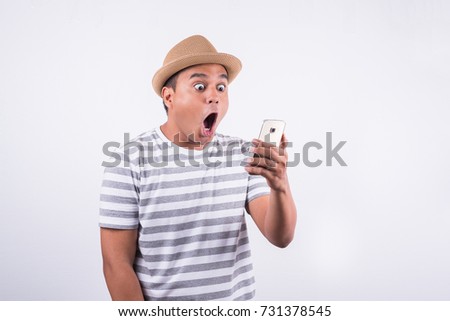 Shocked and surprised asian man looking smartphone Royalty-Free Stock Photo #731378545