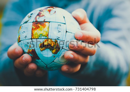 Small Hands holding the world in Vintage style Royalty-Free Stock Photo #731404798