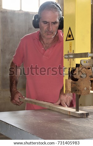 carpenter cutting wood on a band saw