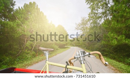 Look back from car running. Bicycle on the truck and curve road background